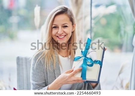 Picture of woman holding a gift in restaurant