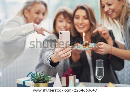 Picture of group of girls with birthday cake taking selfie