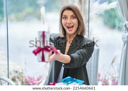 Picture of woman holding a gift in restaurant