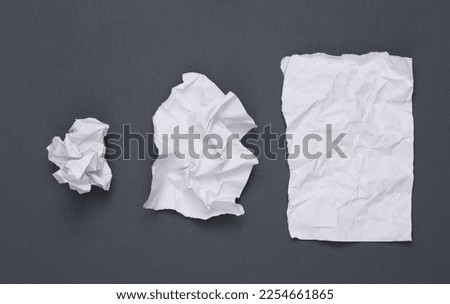Step by step process of crumpling paper into a ball on gray background Royalty-Free Stock Photo #2254661865