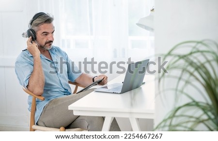 Portrait of happy caucasian business senior man casual cloths shirt work in home office desk using head phone computer. Small business employee freelance online sme marketing e-commerce telemarket 