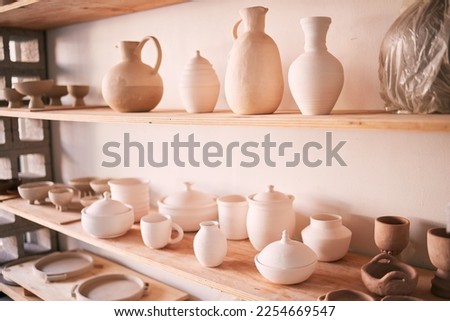 Ceramics, dishes and pottery on shelf in studio, creative store and manufacturing startup. Clay products, background and shelves in workshop, small business and retail craft shop of stock production