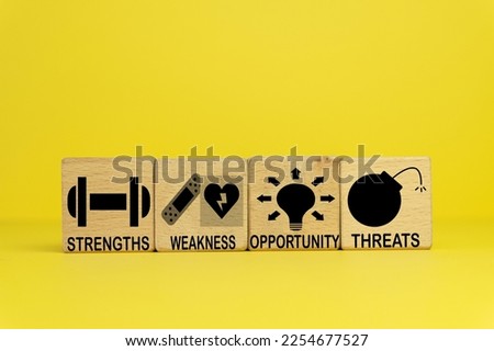  SWOT analysis,business analysis, strategy, planning concept.,SWOT(Strengths, Weaknesses, Opportunities and Threats) word and icon on wooden cubes over yellow background.