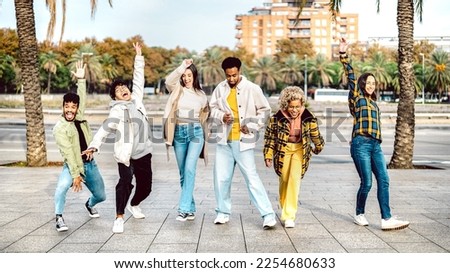 Multicultural friends walking at Barcelona boardwalk on funny mood - Genz guys and girls acting crazy move by urban street on party behaviour - Trendy vacation life style concept - Bright vivid filter Royalty-Free Stock Photo #2254680633