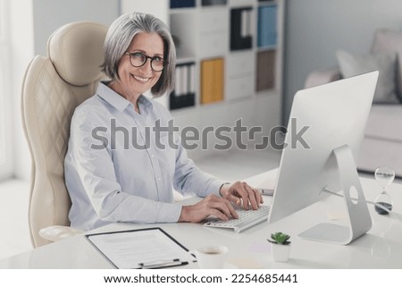 Profile photo of cheerful smart attorney aged lady sit chair keyboard typing email networking office inside Royalty-Free Stock Photo #2254685441