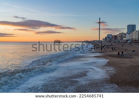 Brighton, UK - December 1st 2022: Brighton Beach during sunset with the i360 Observation Tower and derelict West Pier in the background. Royalty-Free Stock Photo #2254685741