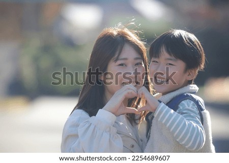 Parent and child making a heart with their hands Royalty-Free Stock Photo #2254689607