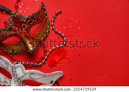 Carnival masks for Mardi Gras celebration with stars and beads on red background, closeup
