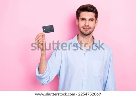 Photo of successful man client customer demonstrate plastic card easy fast payment empty space isolated on pink color background