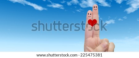 Concept or conceptual human or female hands with two fingers painted with a red heart and smile faces over cloud blue sky background for valentine, romantic, love, couple, young, family or wedding
