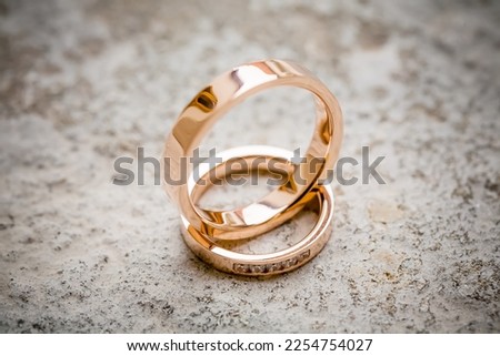 Stylish wedding pink gold rings on stone background. Focused to rings. 