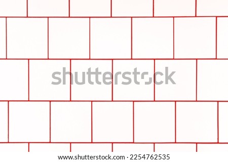 White square ceramic tile with red seam, located horizontally. Abstract background, ceramic tiles texture.	