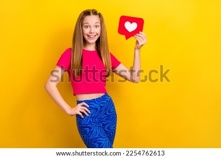 Photo of young funky teenager girl tails hair touch waist hold like paper symbol popular facebook modern vlog isolated on yellow color background