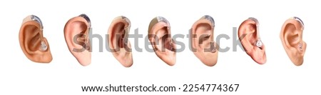 Many ears with hearing aids on white background Royalty-Free Stock Photo #2254774367