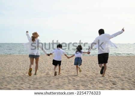 family playing at the beach. happy asian family playing fun on beach