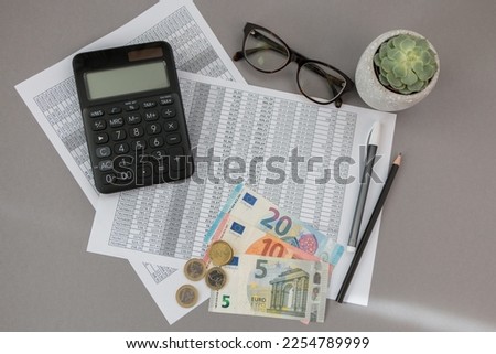 accounting background.  Documents with numbers, calculator, euros  on a gray background