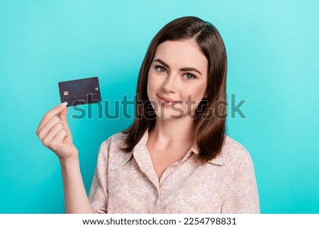 Photo of good mood sweet girl dressed pink shirt rising black debit card isolated teal color background