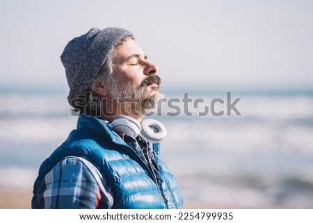 A man on the beach. relaxing deep breathing. Winter Royalty-Free Stock Photo #2254799935