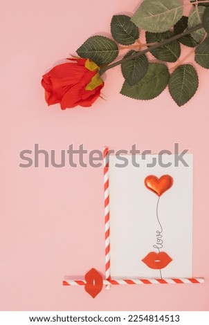 Valentine's day.Flat lay minimal concept with red rose and white gift card.Red lips on red and white straw on pink background. Creatively made copy space.Modern concept for modern love.