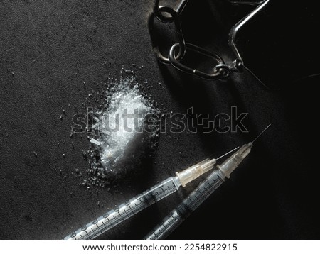 Handcuffs, drug syringe and drug powder