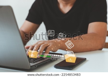 Data transfer, Transfer file of data between folder, Backup data, Exchange of file on folder. Hand using laptop and smartphone waiting for transfer file process with loading bar icon on virtual screen Royalty-Free Stock Photo #2254853483