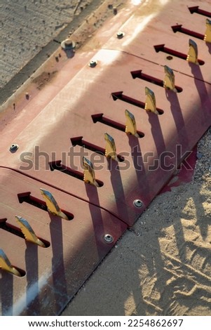 Tire spikes in an area of enhanced security to keep cars or trucks out of restricted space in a parking lot. For government or private parking lot or building in an urban or suburban area of town. Royalty-Free Stock Photo #2254862697