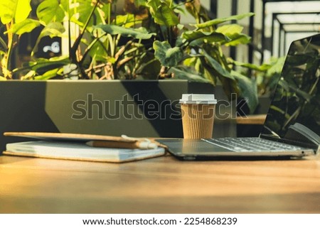 Mock up of modern laptop at table in co-working space. Remote Freelancer's place of work. Study and work online. Remote business education. Concept of webinar. E-learning Workstation Take away