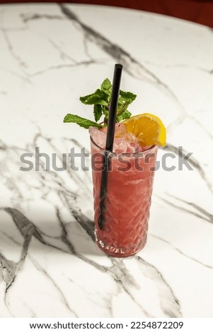 Refreshing ice cocktail with mint, lemon and strawberry in a glass