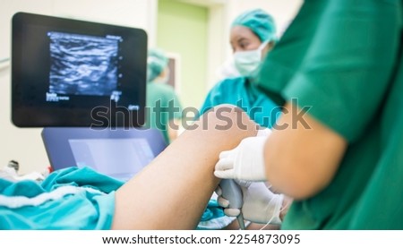 Selective focus at ultrasound probe.Doctor doing the peripheral nerve block under ultrasound guidance before operate on patient.Emergency painkiller in operating room.Medical concept. Royalty-Free Stock Photo #2254873095