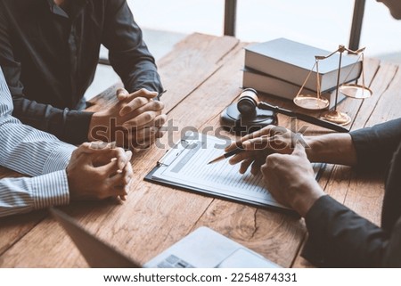 A young Asian lawyer or legal advisor clarifies information about business deals. The signing of investment contracts in accordance with laws and regulations. Royalty-Free Stock Photo #2254874331