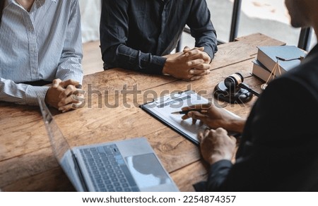 A young Asian lawyer or legal advisor clarifies information about business deals. The signing of investment contracts in accordance with laws and regulations. Royalty-Free Stock Photo #2254874357
