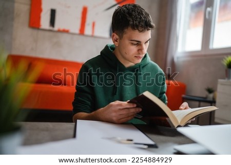 one young man caucasian teenager student learning study reading book while sitting at home prepare exam or work on project real people education concept copy space Royalty-Free Stock Photo #2254884929