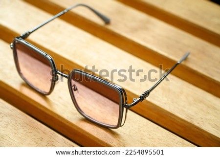 Summer accessories, sunglasses on wooden board, top view and copy space.