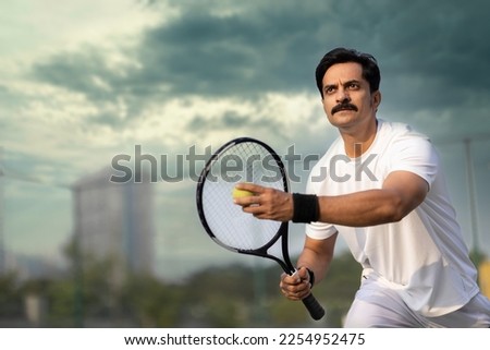  Male tennis player ready to serve at tennis court. Royalty-Free Stock Photo #2254952475