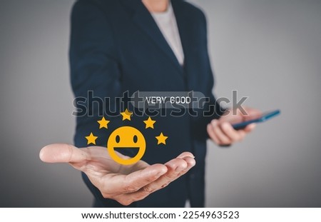 Man hand using smartphone with popup five star icon and happy smile face for feedback review satisfaction service.