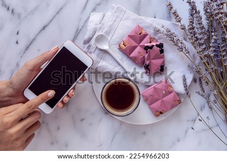 Hands taking a picture of a chocolate