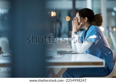 Nurse, burnout stress and black woman in hospital feeling pain, tired or sick on night shift. Healthcare, wellness and female medical physician with depression or anxiety while working late on laptop Royalty-Free Stock Photo #2254998247