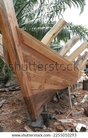 traditional wooden boat construction in the village using hand tools Royalty-Free Stock Photo #2255010293