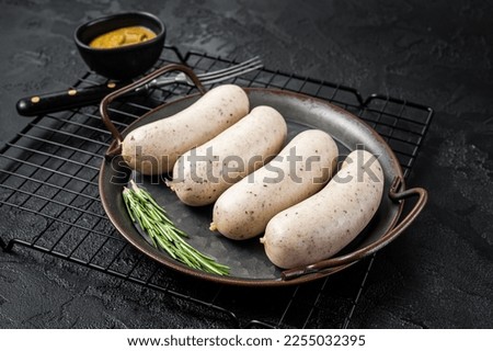 Traditional German Bavarian white sausage in steel tray with mustard. Black background. Top view. Royalty-Free Stock Photo #2255032395