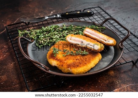 Cordon bleu chicken fillet cutlet with ham and cheese. Dark background. Top view. Royalty-Free Stock Photo #2255032547
