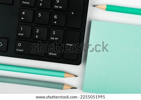 Colored paper with important message lying desk near keyboard. Main information written on notebook. School supplies. Multiple Assorted Collection Office Stationery.