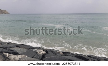 waves crashing against rocky shore mountains by the seaside