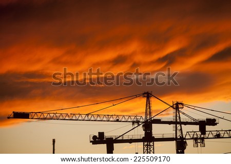 Color picture of some cranes on a construction site, as dusk.