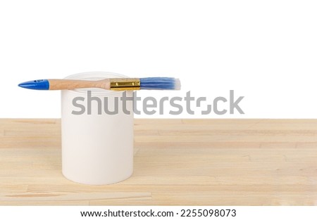 white paint with a brush on a wooden background with texture close-up