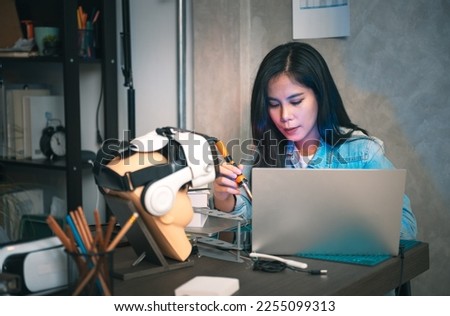 Concentrate asian woman wiring circuit board and testing program for Virtual Reality robotic control system, Engineer and technician student doing graduation project.