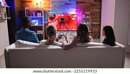 Rear View Of An People Playing Video Games At Home