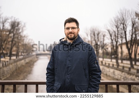 Front view of one adult caucasian man bearded male standing in town in winter cold day real people copy space waiting alone real people Royalty-Free Stock Photo #2255129885