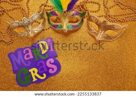Mardi gras or carnival mask with beads on gold glowing background. Venetian mask.