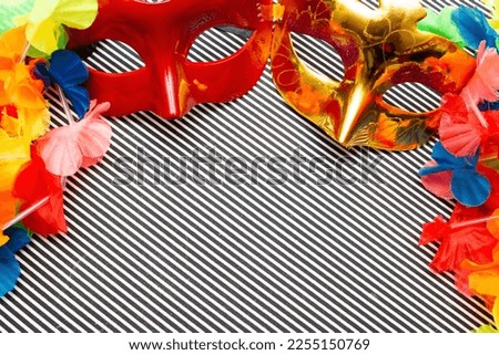 carnival masks on a black and white striped background and colorful flowers