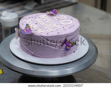 20 years old frosted cake decorated with a cream handmade phrase, butterflies, pearls , sprinkles by baker designer